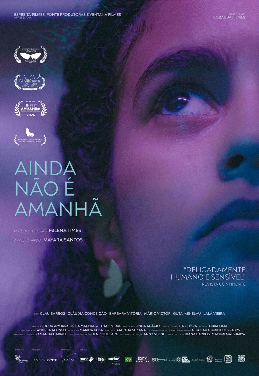 Cartaz do filme “Ainda Não É Amanhã” mostra close no rosto de uma jovem negra olhando para cima, sob iluminação azul e rosa. Traz prêmios conquistados, nomes da equipe, e a frase: “Delicadamente humano e sensível”.