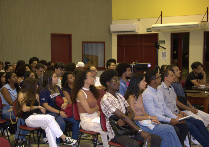 Diversos alunos estão sentados assistindo a palestra