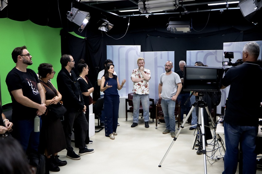 Pessoas reunidas no estúdio da TV UFOP, com equipamentos de filmagem.