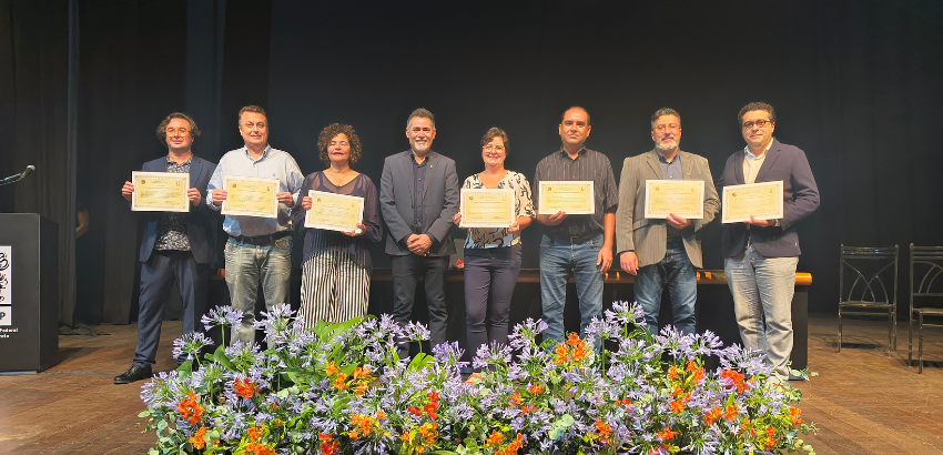 A foto mostra um grupo de oito pessoas, sete delas seguram os diplomas de posse. O único que não segura é o reitor Luciano Campos.