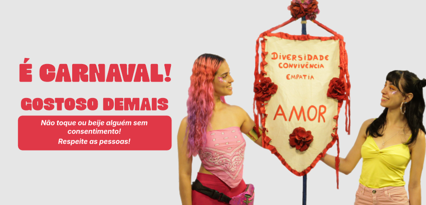 Duas pessoas seguram estandarte de Carnaval. 