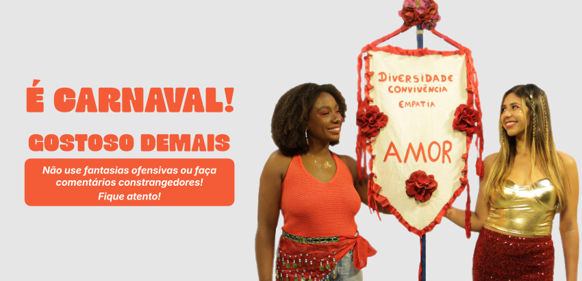 Duas pessoas seguram estandarte de Carnaval. 