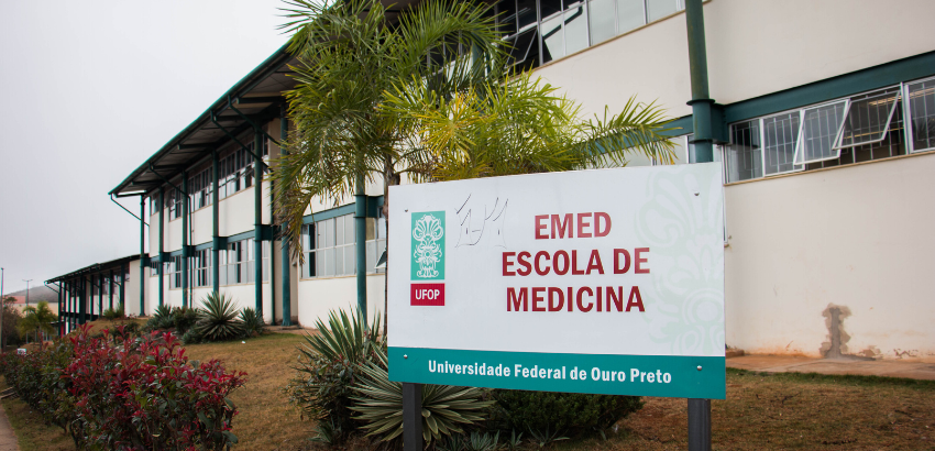 Imagem com fachada e placa da Escola de Medicina da UFOP