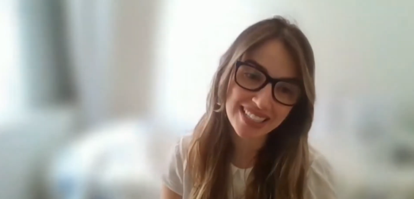 Mulher branca, de óculos, em primeiro plano, sorrindo. Mariana é professora da UFOP.