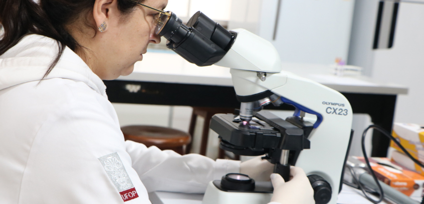 Pesquisadora do Laplac examina amostras de pacientes durante visita ao laboratório