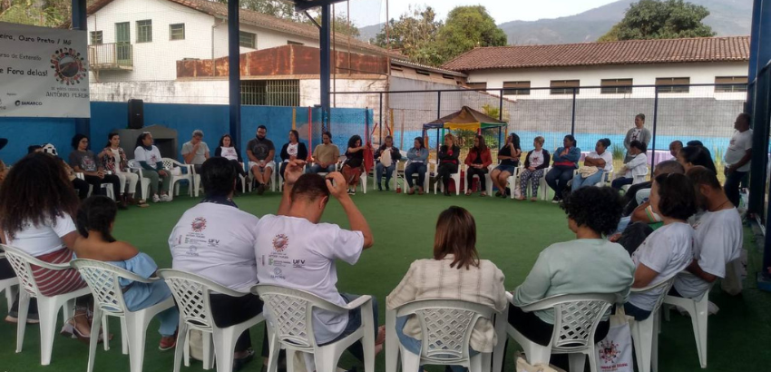 Em uma roda, voluntários e comunidade juntos em uma das atividades do projeto.