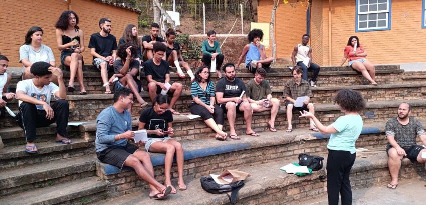 Sentados em uma escada, esudantes participam de reunião no Conjunto I de Mariana.