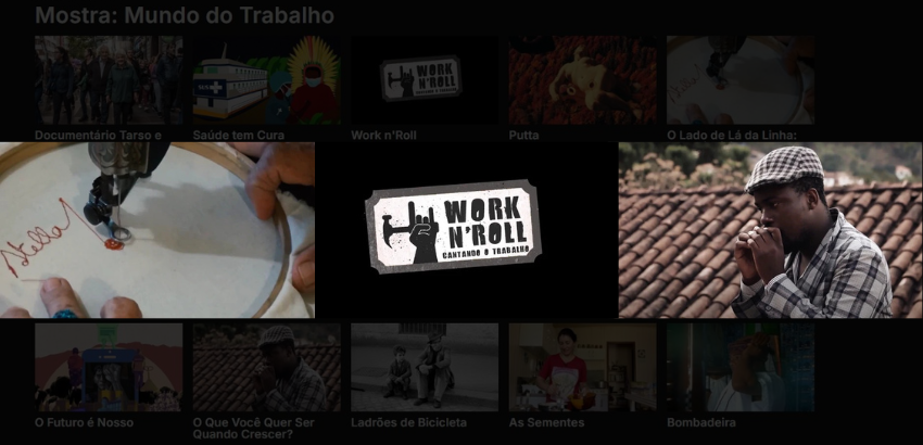Tela de seleção de filmes da mostra “Mundo do Trabalho”, com miniaturas de diversos documentários. No centro, em destaque, aparece o título “Work n’Roll: Cantando o Trabalho”, com um logotipo em preto e branco que mostra uma mão fazendo o gesto do rock. À