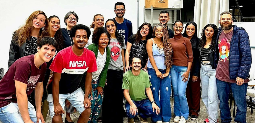 Grupo diverso de pessoas adultas sorrindo em foto coletiva em ambiente interno