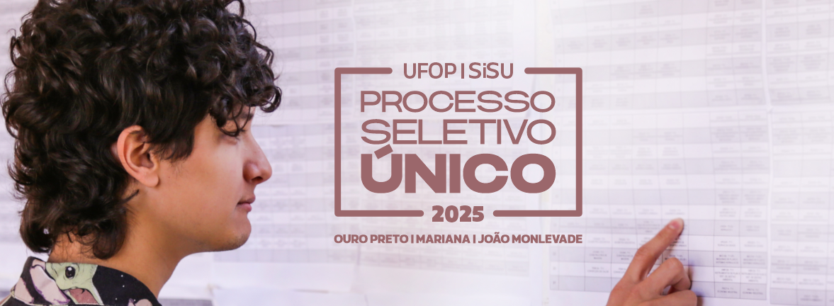 Um jovem branco de cabelos pretos cacheados, em frente a um mural, checa uma lista. No centro, há o texto: "UFOP SiSU 2025 - Processo Seletivo Único - Ouro Preto, Mariana, João Monlevade"