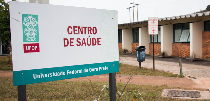 Imagem de placa do centro de saúde da UFOP com emblema da universidade