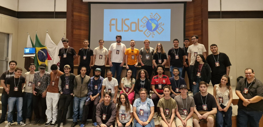 Foto em grupo dos participantes da primeira edição do Festival Latino-Americano de Instalação de Software Livre no auditório do ICEA/UFOP, em João Monlevade. Estudantes, professores e organizadores, posam em frente ao palco abai