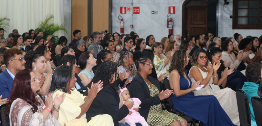 Imagem mostra formados do curso de especialização sentados durante cerimônia de diplomação. 