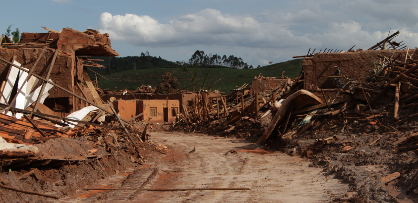 Imagem mostra uma rua cheia de lama e os destroços das casas que foram destruídas pelo Rompimento da Barragem de Fundão, no distrito de Bento Rodrigues no ano de 2015, em Mariana.