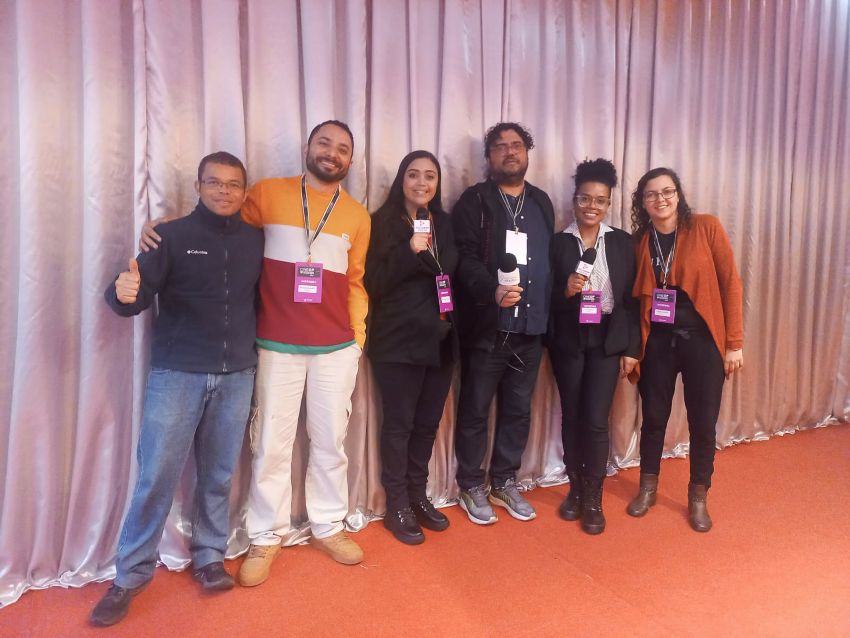 Integrantes das equipes da Rádio UFOP e da Rádio UFMG Educativa posam juntos durante a cobertura do CINEOP 2024, marcando a parceria entre as duas emissoras universitárias.